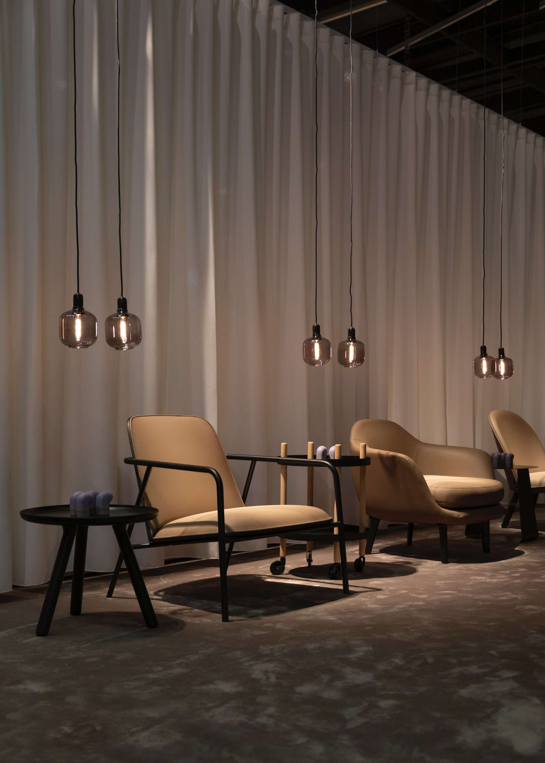 Dämmrige Lobby Situation mit Lounge Sesseln und Hängeleuchten